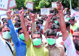 Members of the All India TB Control Employees Association wear H1N1 protection masks during a demonstration demanding permanent jobs and hike in salaries at Jantar Mantar in New Delhi on Sunday. 