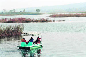Tourists enjoy a motorboat ride in the Assan Lake located on Ukhands border with Himachal