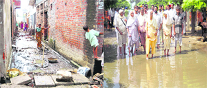View of a street where a social organisation is constructing a road and (right) residents walk through stagnant street at Chhappar village in Ahmedgarh on Saturday.