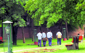 Students in uniform stroll in a park during school hours.
