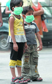 Children wear masks as they wait to undergo swine flu test at the Ram Manohar Lohia Hospital in New Delhi on Friday.