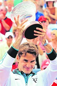 Roger Federer holds up the championship trophy after defeating Novak Djokovic 6-1, 7-5 at the Cincinnati Open tennis tournament