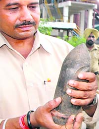 A police officials shows a bombshell in Dadu Majra