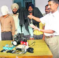 A police official shows the stolen articles recovered from the accused in Chandigarh