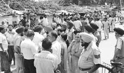 Jhuggi dwellers gather at the encroachment area to stop GMADA from removing their hutments at Phase I in Mohali 