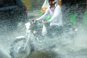 A motorist drives through a waterlogged street after heavy downpour in New Delhi on Wednesday.