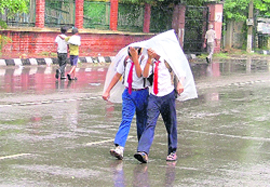 Two boys make their way back home through a drizzle in Ludhiana on Wednesday.