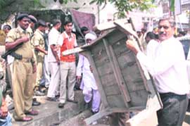 Employees of the municipal corporation remove encroachments from the busy market area of Bakshi Nagar in Jammu