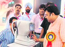 A member of the Optical Association explains the function of auto-refractometer at the National Optical Exhibition in Ludhiana on Saturday. 