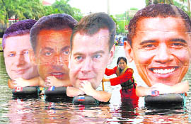 An environment activist arranges cutouts of (left to right) Canadian Prime Minister Stephen Harper, French President Nicolas Sarkozy, Russian President Dmitry Medvedev and US President Barack Obama in a pool of water during a protest in Jakarta on Saturday.