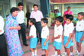 Slum children with Jean Rodrigues after receiving gift hampers at Strawberry Fields World School