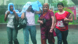 Women caught in the rain in New Delhi on Sunday morning.