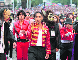 Michael Jackson impersonator Hector Jackson (C) dances with thousands of other fans to Thriller in celebration of the late singer's 51st birthday in Mexico City on Saturday. Over 12,000 fans danced to Michael Jackson's Thriller at the event, breaking a Guinness record. 