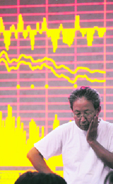 An investor stands in front of a stock information board at a brokerage house in Hefei, Anhui province on Monday.