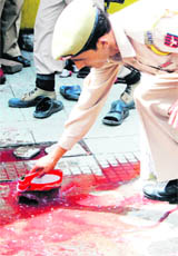 A policeman washes the blood-soaked area after two CRPF jawans were shot dead by militants in Srinagars Lal Bazar on Monday.