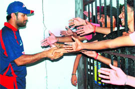 Indian skipper MS Dhoni shakes hands with fans at PCA stadium in Mohali on Tuesday.