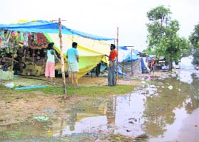 A vendor puts a PVC sheet on his stall at the Chhapar Mela site