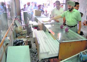 The shop owner shows the ransacked watch shelves in Ghuman Mandi in Ludhiana
