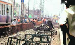 Irate commuters block a track as they express their anger over delay of train services in Mumbai. 