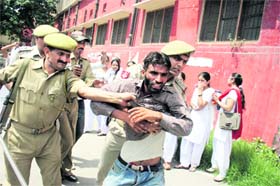 Policemen arrest a protester from Girls College in Jammu