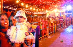 Women with kids stand in a queue to pay obeisance at Baba Sodal Mandir in Jalandhar