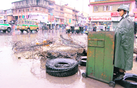  A CRPF jawan keeps vigil in Srinagars rain-soaked Lal Chowk on Thursday. 