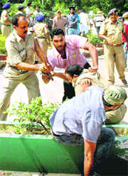 The SHO of the Industrial Area police station comes to the rescue of a policeman being beaten up by a student outside SD College in Chandigarh on Friday.