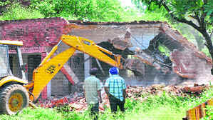 Demolition of NAC building under way at Mani Majra during a cleanup drive by the municipal corporation in Chandigarh on Friday. 