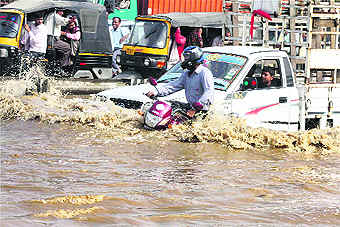 Vehicles pass through a waterlogged road after heavy rain in Gurgaon on Friday. 
