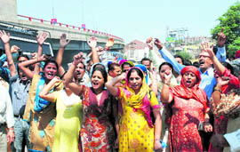 Families of the striking SRTC employees protest at Bikram Chowk in Jammu on Friday.