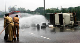 Firefighters try to contain damage due to an accident on Delhi-Jaipur Highway that passes through Gurgaon, on Saturday.