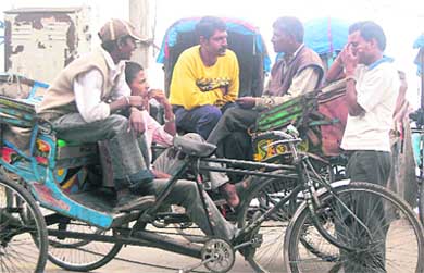 Due to the tourist season going lean following rains this week, rickshaw pullers wait for tourists in Mussoorie