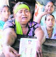 Meena with the photograph of her son Anil, who died after asphyxiation in Ludhiana on Saturday.