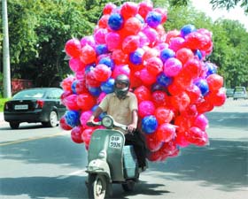 THE ACT OF BALANCING: A man carries balls on his scooter in New Delhi