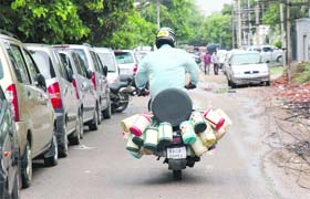 A tiffin service provider goes about his job on a scooter in Gurgaon