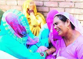 Villagers console family members of Hawa Singh and Moni, who allegedly committed suicide, in Shalaroo village in Karnal district