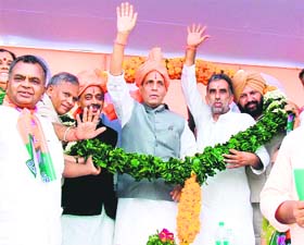 BJP president Rajnath Singh and other leaders are welcomed by party workers in Rohtak