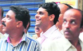 Investors cheer outside the BSE as they watch the index on the digital broadcast in Mumbai