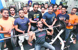 A bodybuilder takes part in a shoulder competition at a health club in Ludhiana.