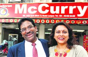 McCurry restaurant owner AMSP Suppiah and his wife Kanageswary pose in front of their eatery as they celebrate a court victory over US fast food giant McDonalds in Kuala Lumpur, Malaysia