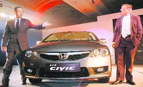 Masahiro Takedagawa (L), CEO, Honda Siel Cars India, and Siddharth Shriram, chairman, pose with new Honda Civic in New Delhi