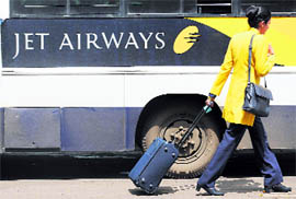A Jet Airways flight attendant walks past a company coach at the Mumbai airport on Tuesday.