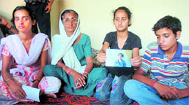 Family members show a photograph of Shefali Verma, who committed suicide in Durga Nagar, Jammu.
