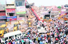 People gather outside a shopping centre which collapsed in Faridabad