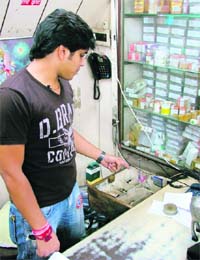 The owner of a medical store shows the empty cash drawer