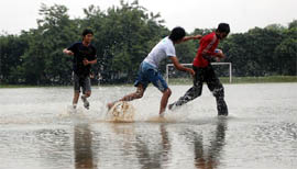 Boys play in a waterlogged playground in Faridabad on Thursday.