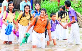 Students only too happy to wade their way through a flooded road in Dehradun