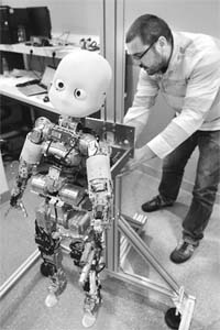 Vincent Padois, head tutor at the Pierre and Marie Curie University who teaches robotics and is "babysitting" the Paris ICub, makes a demonstration with ICub robot