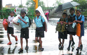 Children struggle to go to school in New Delhi on Friday.