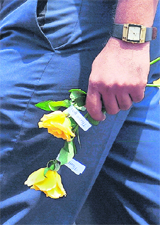 A Jet Airways staffer holds roses presented by the management as a goodwill gesture outside the city airport in Mumbai on Friday. 